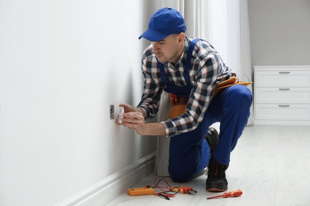 A residential electrician is installing an outlet.