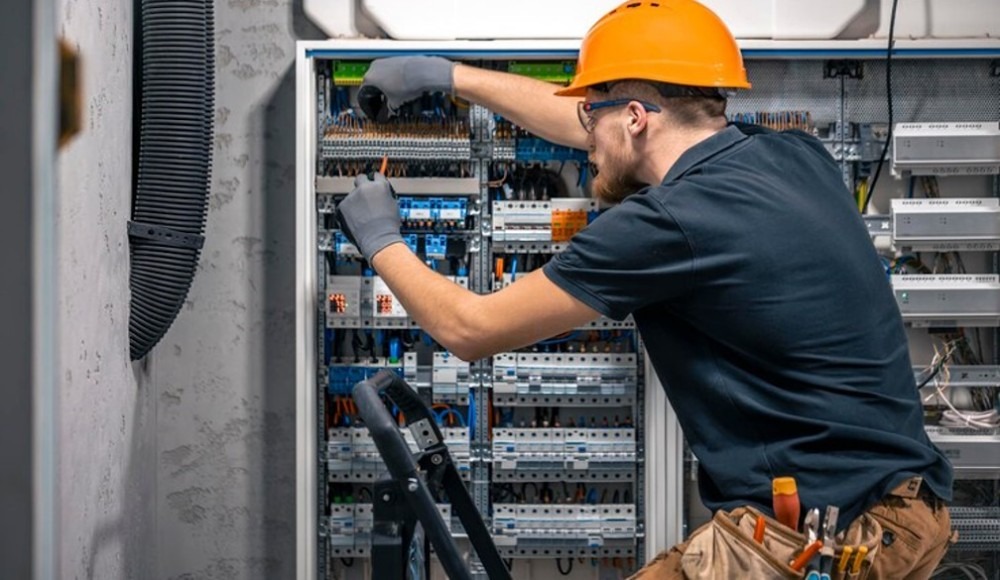 Commercial electrician maintaining an electrical system in a building.