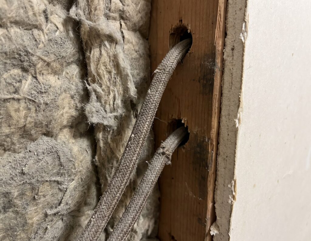 Aged cloth-sheathed wiring inside the wall of an older Palos Hills home