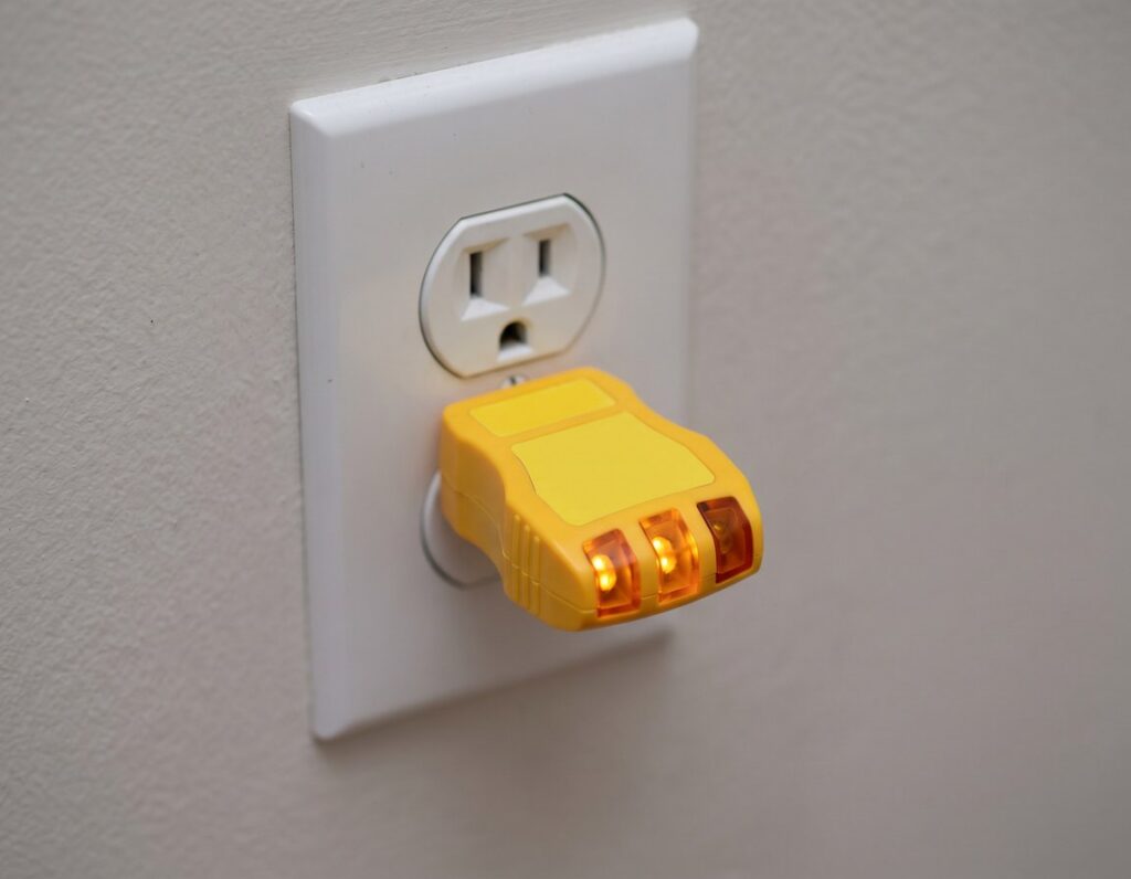 Plug-in receptacle tester checking an outlet during an electrical inspection